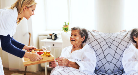 caregiver feeding senior woman