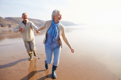 senior couple running at the beach