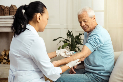 medical worker injecting senior man